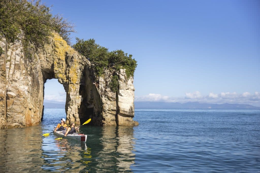 kayakers in the water near cliff