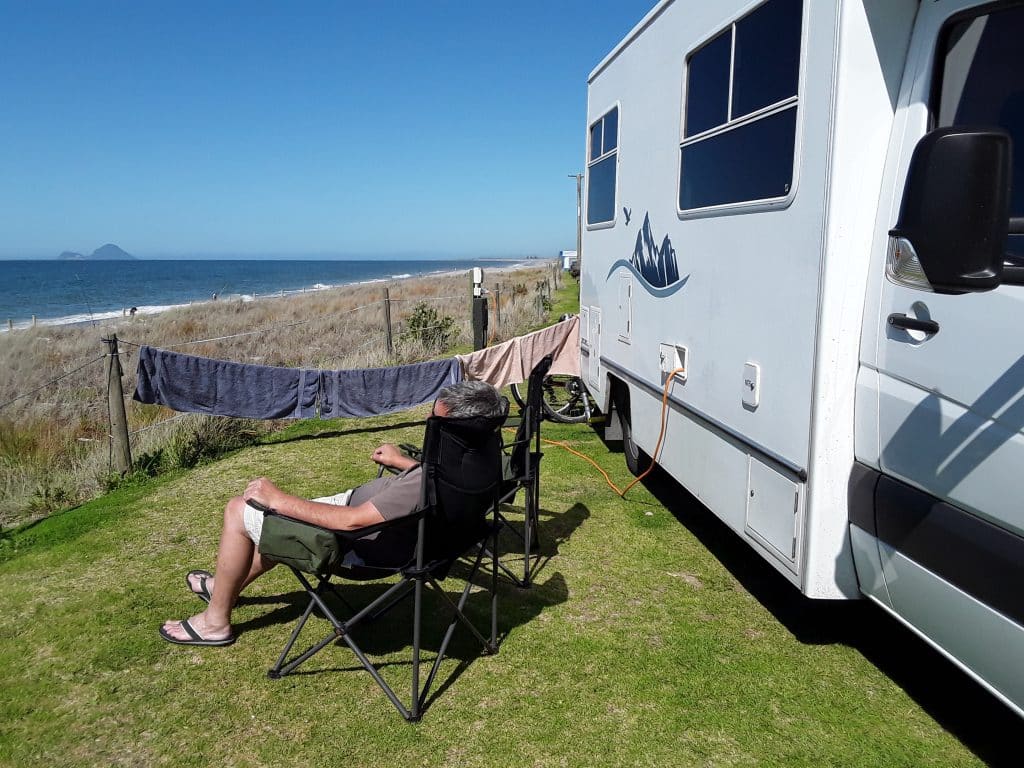 person sat in a chair next to a motorhome